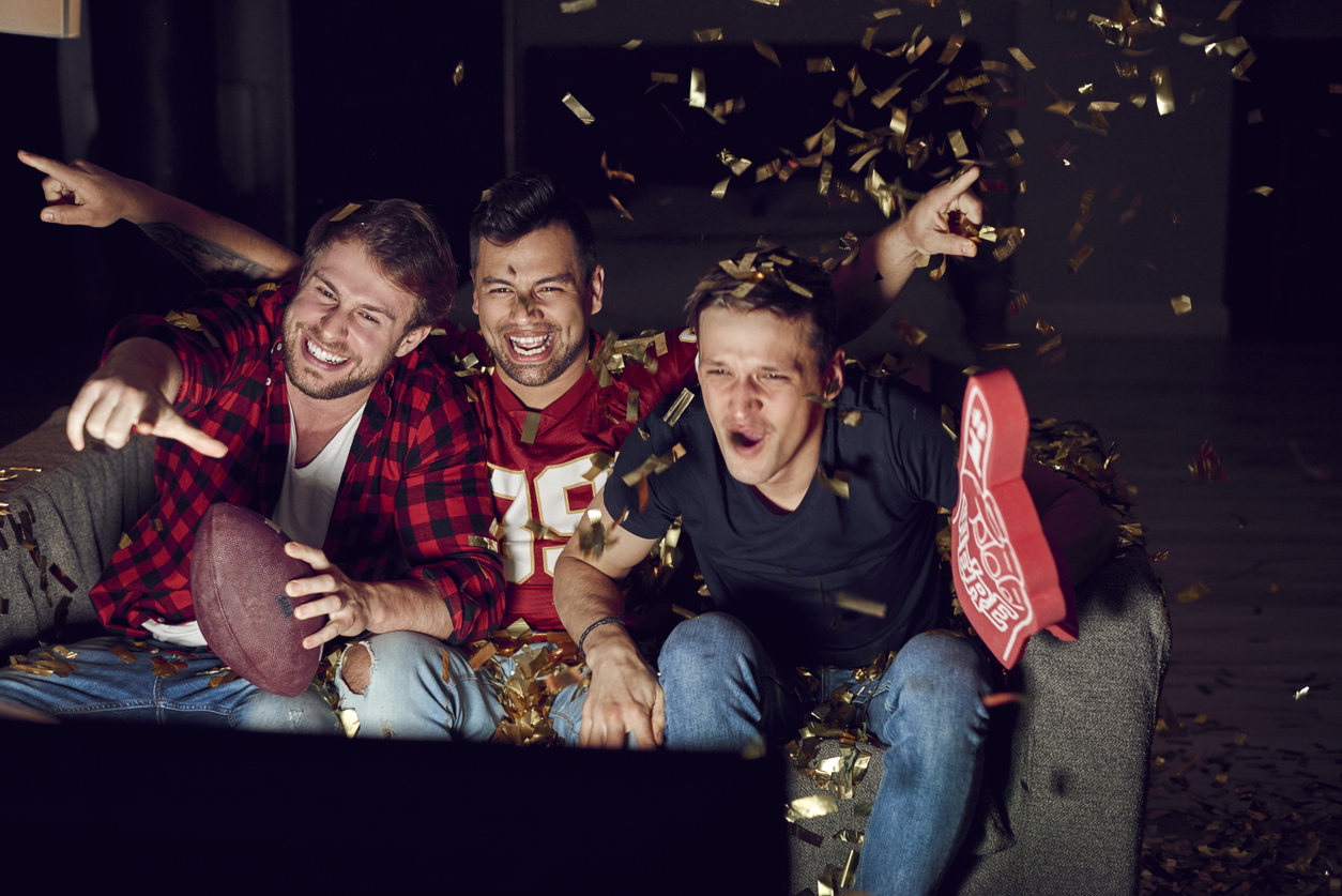 Group of male friends celebrating the victory of their team - watching famous sporting events.