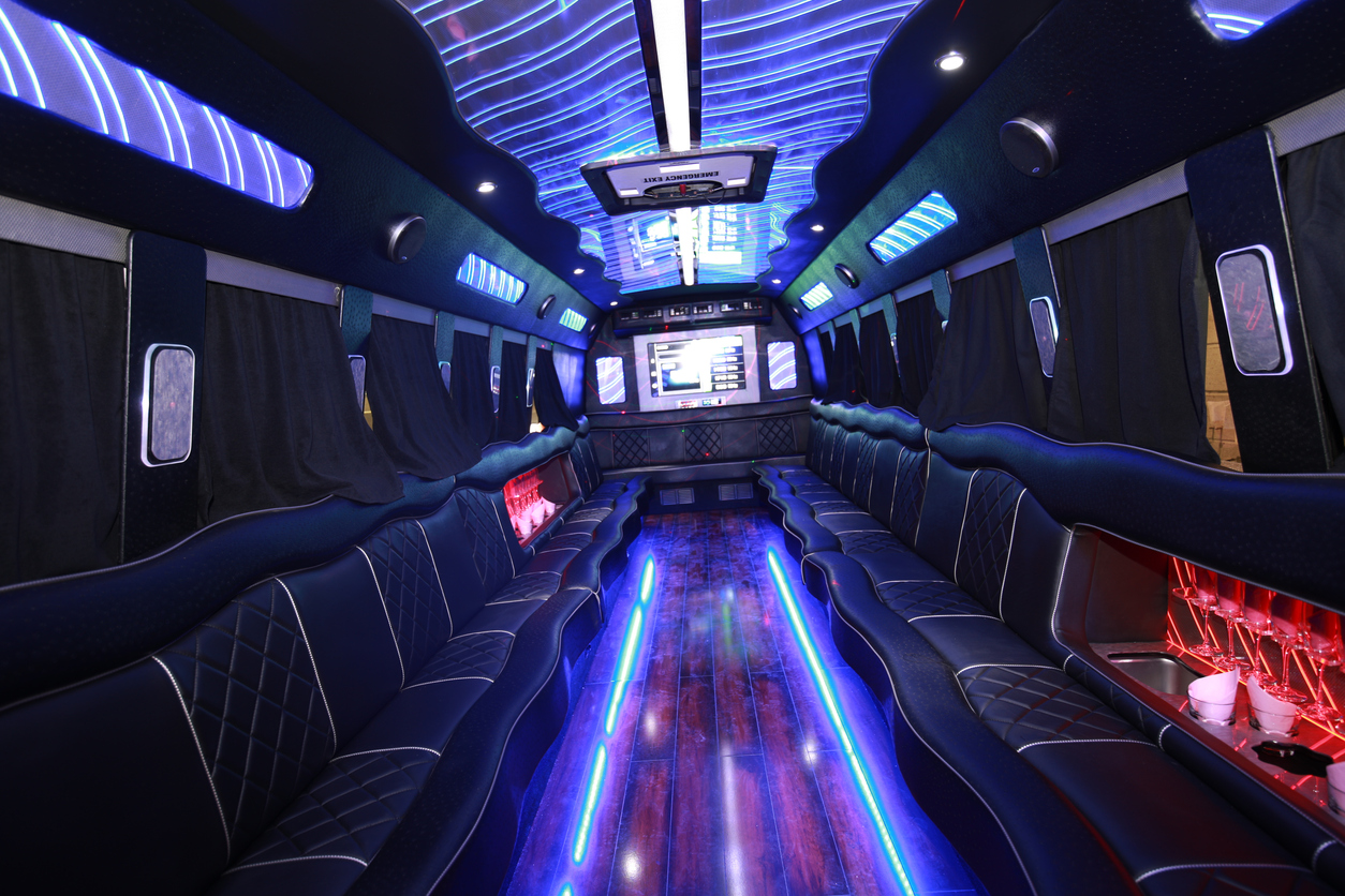 Big party bus filled with comfortable seats and different lights.